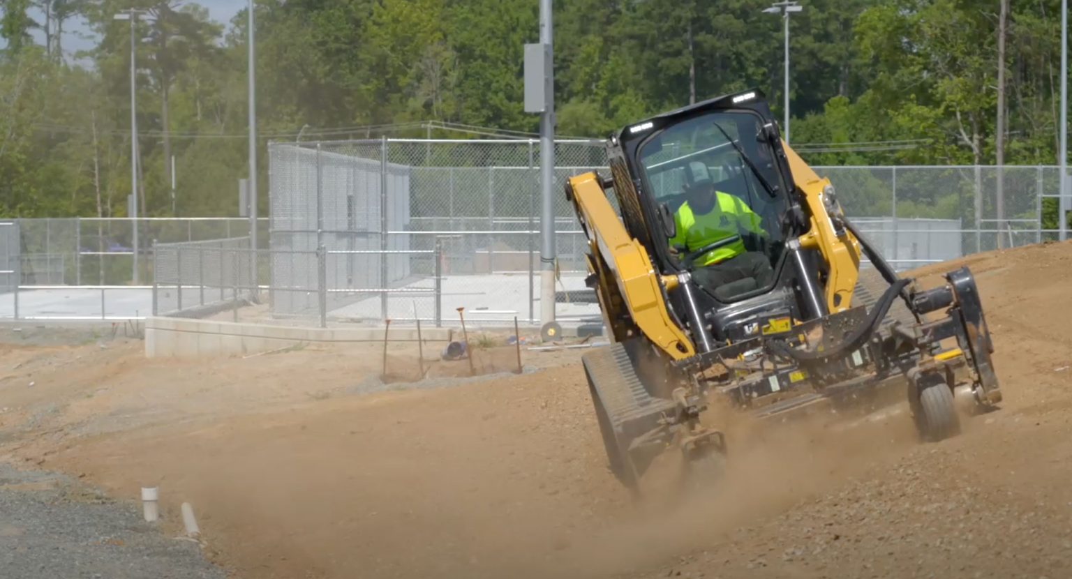 Skid steer working through a dusty outdoor site, showing land clearing and property access cleanup for Liberty and Kansas City area projects.